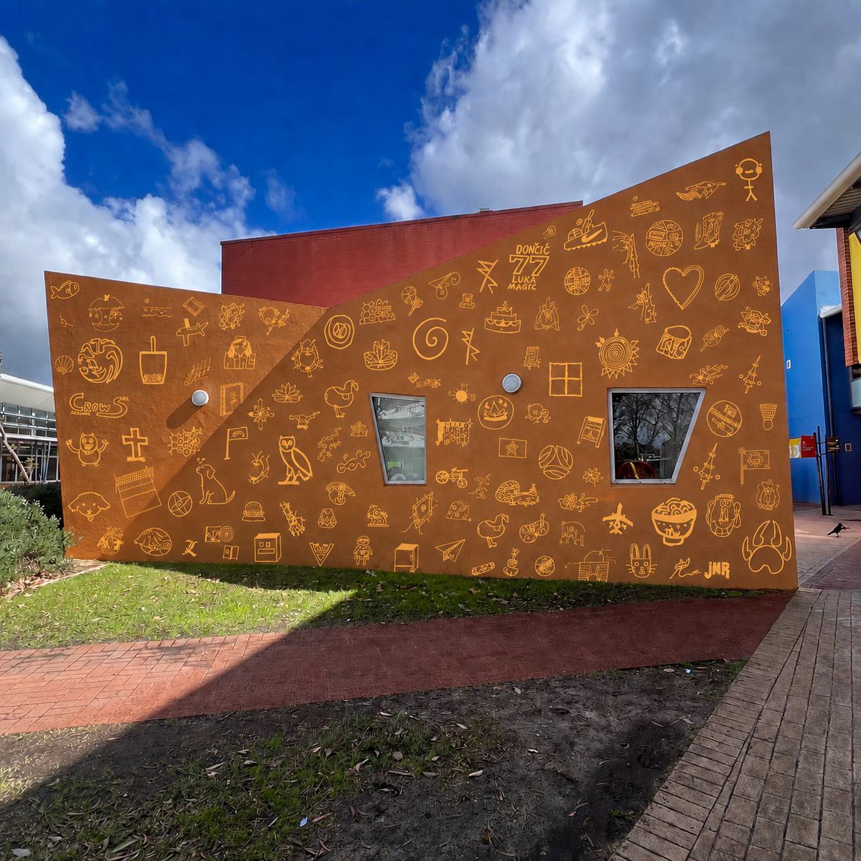 Student symbols applied across an ochre school wall